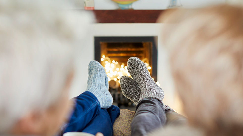 Autumn and winter wellness tips couple sitting fire